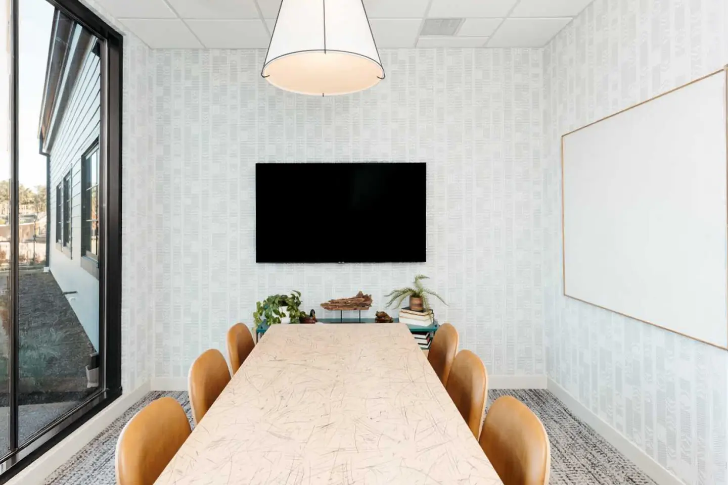 The Pier study room with a table and chairs with a TV mounted on the wall