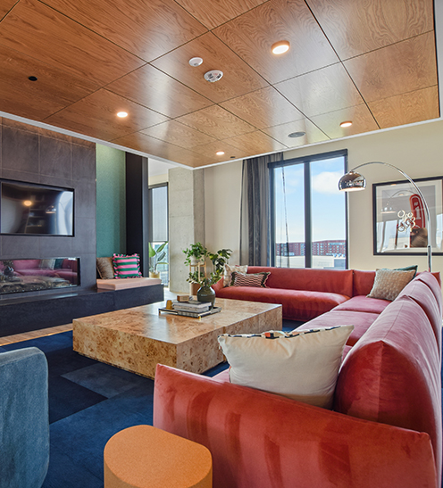 apartment lobby with comfortable seating and a mounted tv